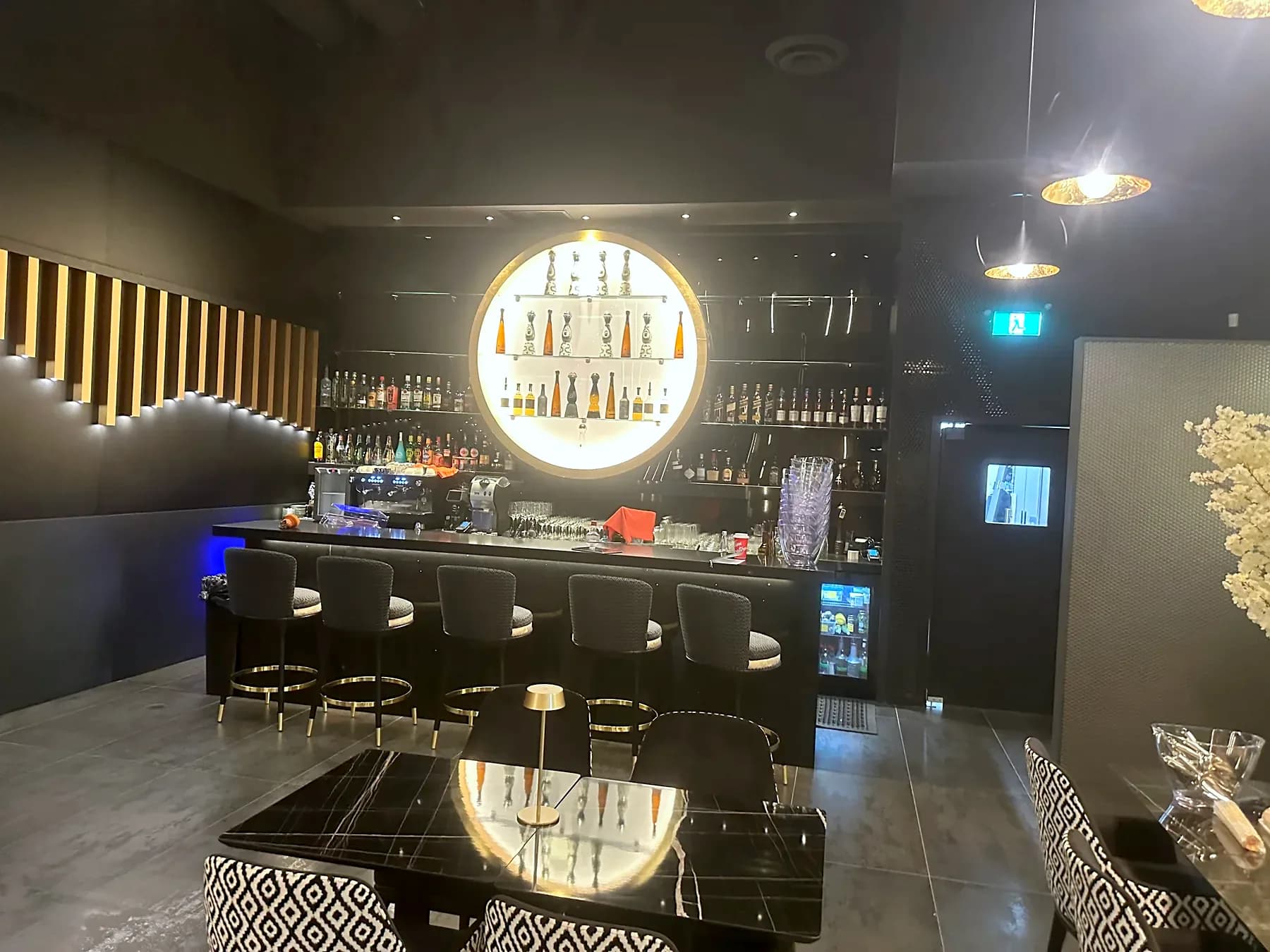 Bar counter and seating beneath a circular pendant light