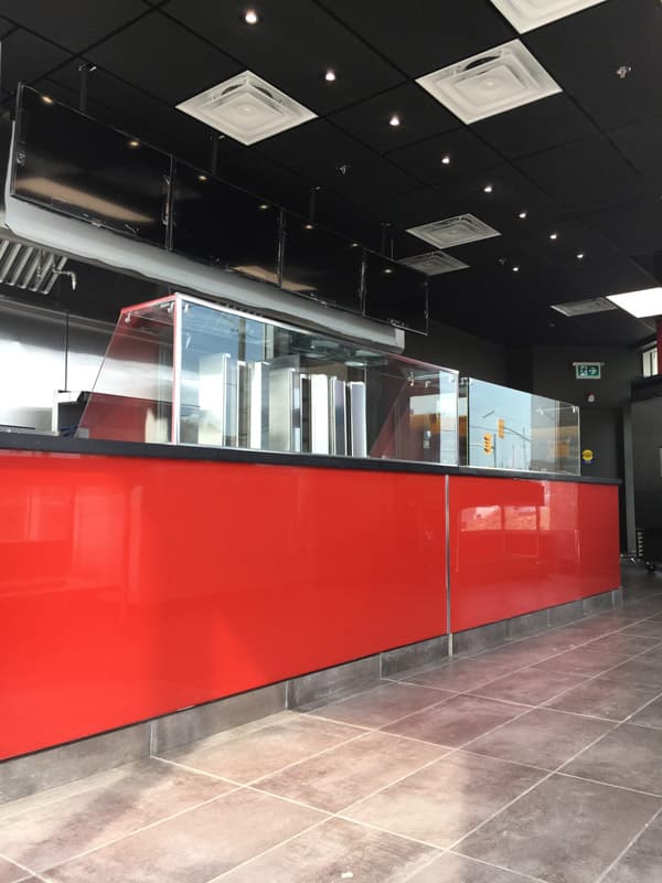 Red food-court counter with a commercial kitchen line behind it